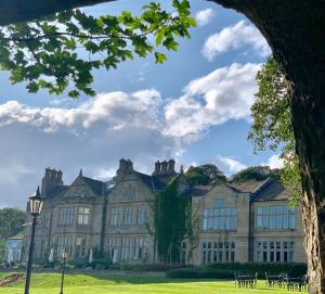 un gran edificio con ventanas en un campo verde en Hollins Hall Hotel, Golf & Country Club, en Bradford