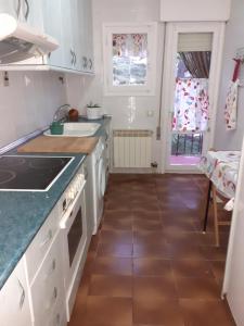 una cocina con armarios blancos y fregadero en Apartamento El Portiel en Gotor