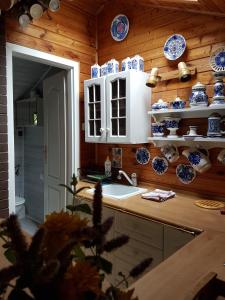 eine Küche mit blauen und weißen Gerichten an der Wand in der Unterkunft Domek Letniskowy na Kaszubach lub Apartament z Kominkiem in Puck