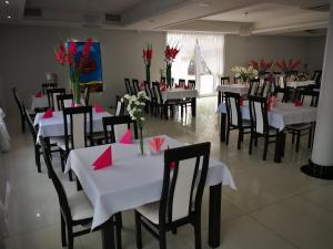 グダニスクにあるVolterの白いテーブルと黒い椅子、赤いナプキンを用意したレストラン