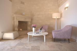 uma sala de estar com uma mesa e 2 cadeiras e uma lareira em Residence Masseria Santa Lucia em Matera