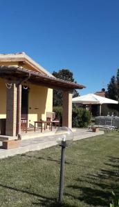 un patio con una casa con mesa y sillas en Agriturismo Le Chiare Stelle, en Grosseto