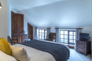 a bedroom with a bed and a tv and windows at Moors Inn in Appleton le Moors