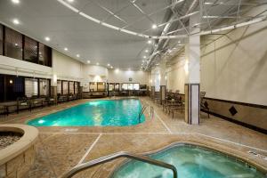 a pool in a hotel with chairs and a spa at Wingate by Wyndham St. Clairsville/Wheeling in Saint Clairsville