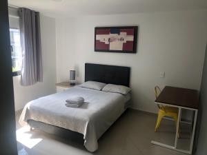 a bedroom with a bed and a desk at Black Sheep Medellin in Medellín