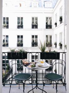 
a dining room table with chairs in front of it at Hotel des Grands Boulevards in Paris

