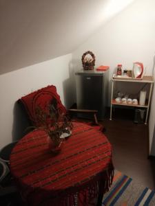 a bedroom with a red bed with a vase on it at Buşteni House in Buşteni