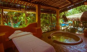 a room with a bed and a jacuzzi tub at Le Laurent Boutique Hotel - Adult Only in Arraial d'Ajuda