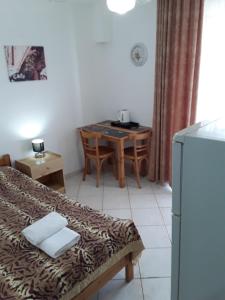 a room with a bed and a table with a telephone at Hause Zorbas in Paralia Dionysiou