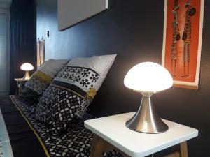 um quarto com uma cama com almofadas pretas e brancas em Maison TONGA piscine - jacuzzi confort em Saint-Pierre