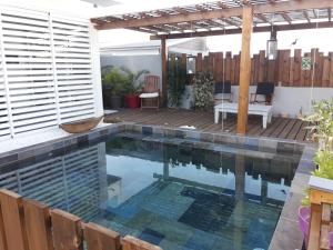 - une piscine dans un jardin avec une terrasse en bois dans l'établissement Maison TONGA piscine - jacuzzi confort, à Saint-Pierre