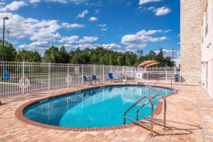 een zwembad met een hek eromheen bij Holiday Inn Express & Suites - Tampa North - Wesley Chapel, an IHG Hotel in Wesley Chapel