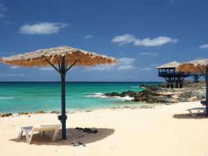- une plage avec 2 chaises, un parasol et l'océan dans l'établissement Ilya Delux nice apartment, à Sal Rei