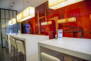 a restaurant with white tables and chairs and a red wall at Holiday Inn Express Tianjin Heping, an IHG Hotel in Tianjin