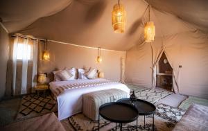 a bedroom with a bed in a tent at Aiour Luxury Camp in Merzouga