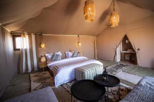 a bedroom with a bed in a tent at Aiour Luxury Camp in Merzouga