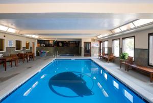 a large swimming pool with blue water in a house at Gray Wolf Inn & Suites in West Yellowstone