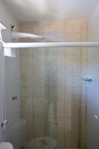 a bathroom with a shower with a tiled wall at Pousada Flor de Noronha in Fernando de Noronha