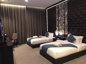 una camera d'albergo con due letti e una televisione di Vangohh Eminent Hotel & Spa a Bukit Mertajam