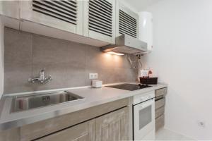 a kitchen with a sink and a stainless steel sink at FLH - Ericeira Beach Apartments in Ericeira