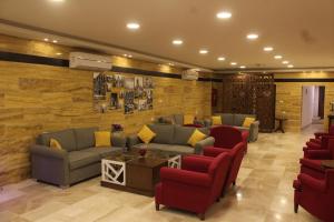 a waiting room with couches and red chairs at Petra Corner Hotel in Wadi Musa