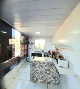 eine große Küche mit einer Theke in der Mitte in der Unterkunft Casa do Maneco in Fernando de Noronha