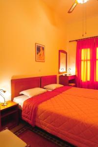 a bedroom with two beds and red curtains at Sibylla Hotel in Delfoi