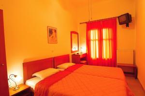 a bedroom with a bed and a red curtain at Sibylla Hotel in Delphi