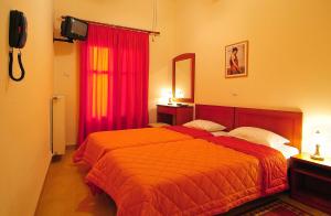 ein Schlafzimmer mit einem Bett und einem roten Vorhang in der Unterkunft Sibylla Hotel in Delphi + 8 Fotos