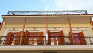 ein Balkon eines Hauses mit Holzfensterläden in der Unterkunft Sibylla Hotel in Delphi