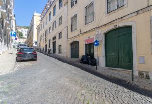 une voiture garée dans une rue à côté d'un bâtiment dans l'établissement FLH Sé Apartment, à Lisbonne