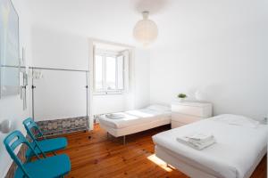 a white room with two beds and two chairs at FLH Sé Apartment in Lisbon