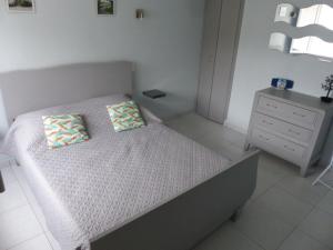 a bedroom with a bed with two pillows and a dresser at Maison JMB in Royan