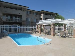 a swimming pool with tables and chairs and umbrellas at Comfort Inn & Suites Boulder in Boulder