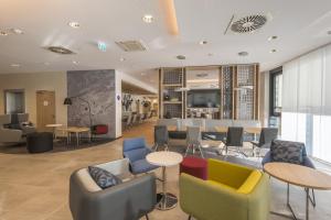 a lobby with chairs and tables and a bar at Holiday Inn Express - Wuppertal - Hauptbahnhof, an IHG Hotel in Wuppertal