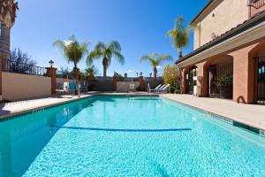 a large blue swimming pool in front of a house at Holiday Inn Express Temecula, an IHG Hotel in Temecula