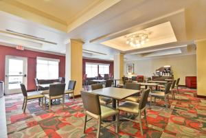 uma sala de jantar com mesas e cadeiras num tapete em Holiday Inn Express & Suites Utica, an IHG Hotel em Utica