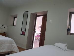 a bedroom with two beds and a mirror and a door at Xplora Hostel Cusco in Cusco