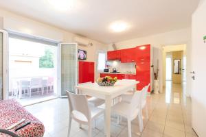 cocina y comedor con mesa blanca y sillas en Villa Lucchese, en Lignano Sabbiadoro