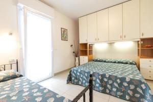 a bedroom with two beds and a window at Villa Lucchese in Lignano Sabbiadoro