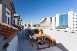 un balcone con tavolo e sedie in legno su un edificio di FLH Luxury Flat near Marquês a Lisbona