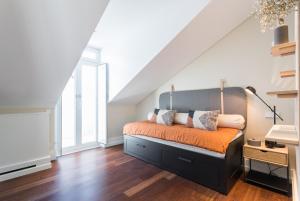 una camera da letto con letto completo di lenzuola e cuscini arancioni di FLH Luxury Flat near Marquês a Lisbona