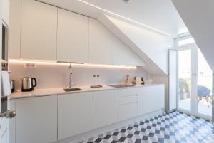 una cucina con armadietti bianchi e pavimento a scacchi di FLH Luxury Flat near Marquês a Lisbona