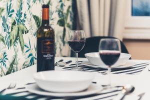 a table with a bottle of wine and two glasses at FatCat Apartments in Krakow +188 photos