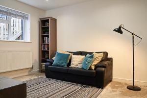 a living room with a couch and a floor lamp at Deluxe Town Center Apartment in High Wycombe
