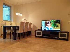 ein Wohnzimmer mit einem TV und einem Esstisch in der Unterkunft Ilmarine Apartment in Tallinn