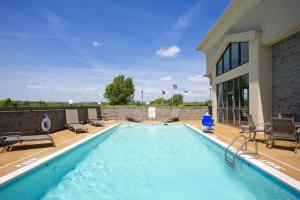 a swimming pool with chairs and a building at Holiday Inn Express Stephens City, an IHG Hotel in Stephens City