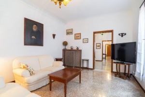 uma sala de estar com um sofá branco e uma televisão em San Marco 4893 em Veneza