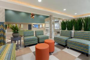 a lobby with chairs and plants in a building at Holiday Inn Express Williamsburg North, an IHG Hotel in Williamsburg