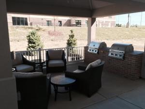 a patio with chairs and tables and a grill at Candlewood Suites Youngstown W - I-80 Niles Area, an IHG Hotel in Austintown
